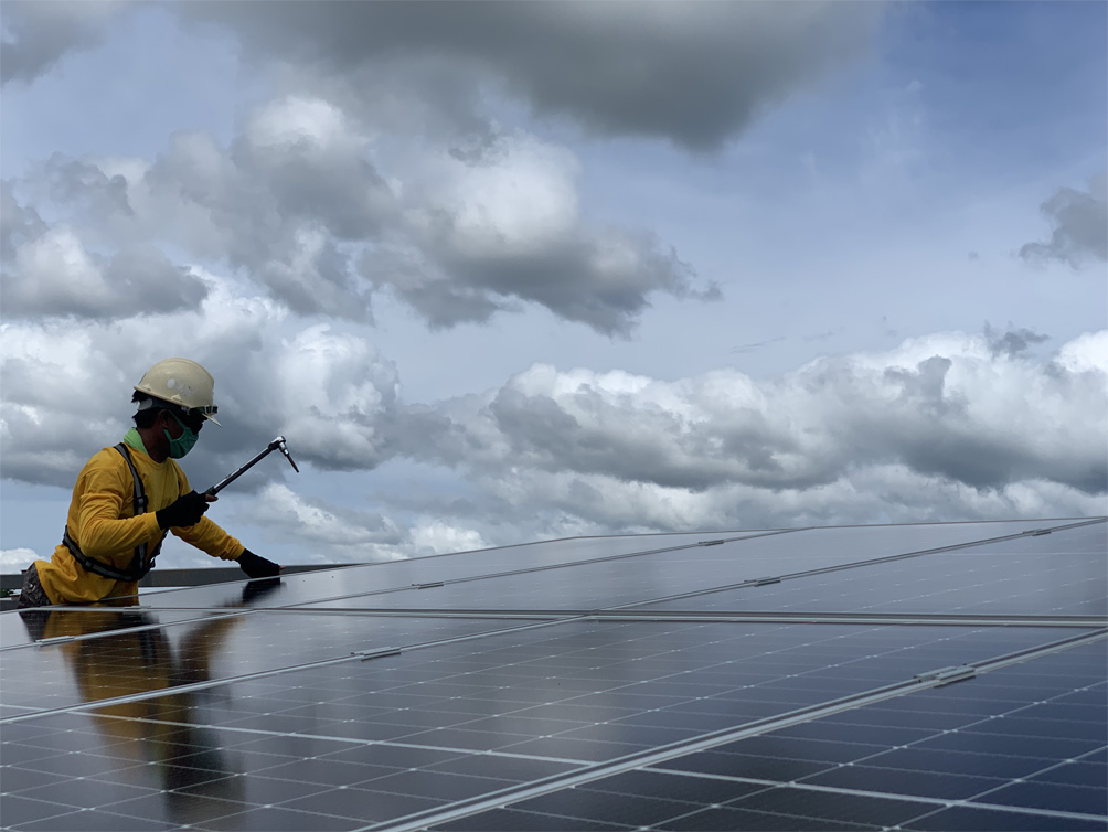 worker fixing a solar panel