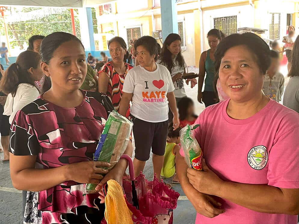 2 women smiling after recieving their Christmas food pack from Kabraso