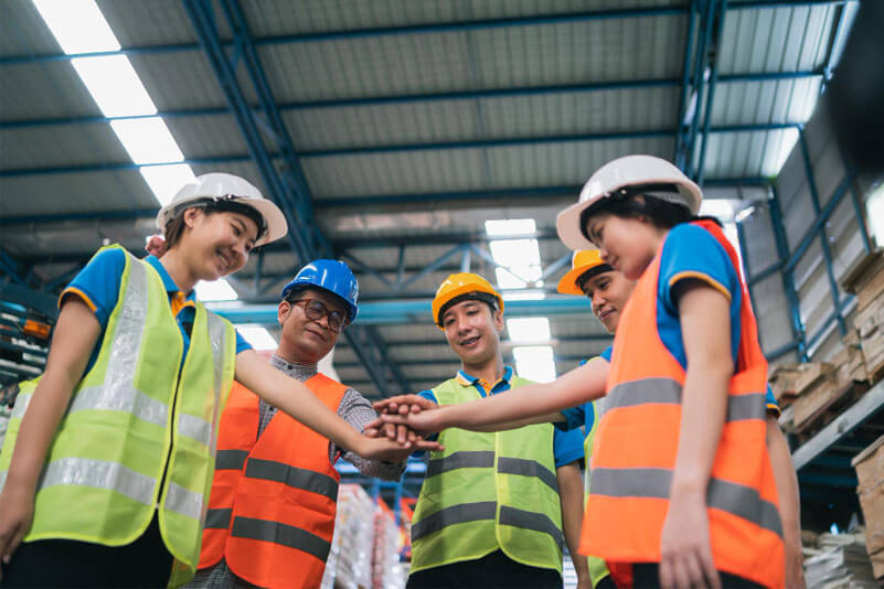 Employees of logistics and warehousing placing their hands together at the middle