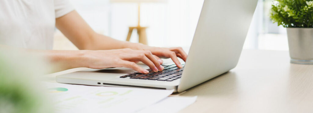A pesron wearing white typing on a laptop