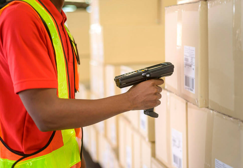 worker in the warehouse using a barcode scanner to inspect products