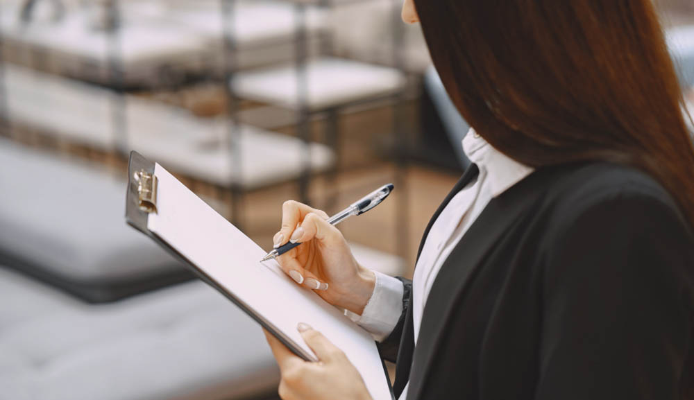 A woman from a service contracting company taking important key terms in a notepad in order to enhance the manpower workforce solution of the company