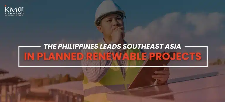 A construction worker wearing a hard hat and reflective vest stands beside solar panels, holding a tablet and looking thoughtfully into the distance. Text overlay reads: ‘The Philippines leads Southeast Asia in planned renewable projects.’ The KMC Kabraso Multi-Purpose Cooperative logo appears in the top left corner