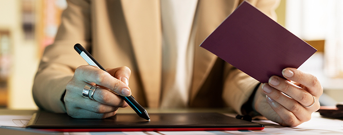 woman holding government permit in one hand while holding a pen in the other hand